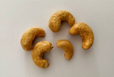 Beyaz arkaplanlı kaju fıstıklarının üst görünümü.