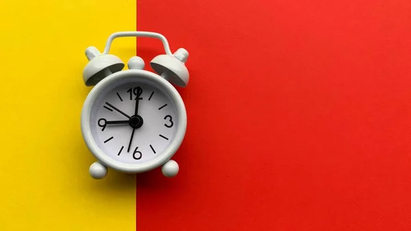 Relógio de alarme branco ligado com fundo amarelo e vermelho. Conceitual — Fotografia de Stock