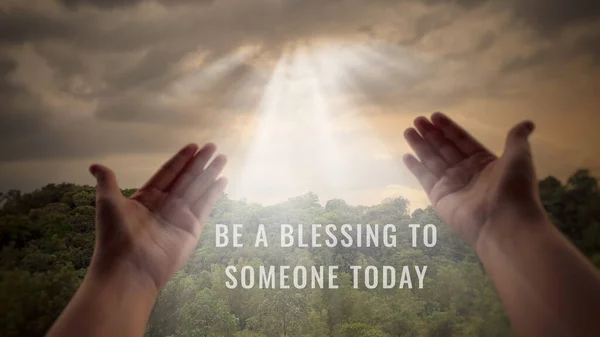 Рука, що тягнеться до сяючого неба з текстом - Будьте благословенням для когось сьогодні . — стокове фото