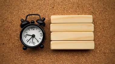 Çalar saatin üst görüntüsü ve kahverengi masa arkası olan tahta bloklar. Boşluk konseptini kopyala