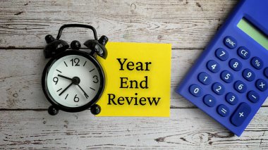 Metnin üst görünümü - Yıl sonu incelemesi. Alarm saati ve hesap makinesi arka planıyla.