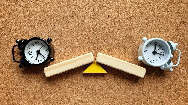 Alarm clocks on a wooden seesaw, both side fall. Success and failure. — Stock Photo, Image