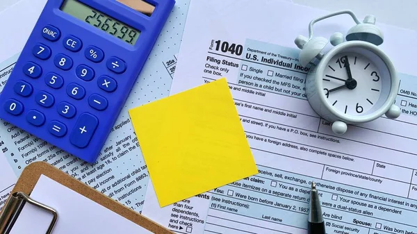 Hesap makinesi, alarm saati ve kalem arkaplanı olan vergi formuna sarı not. Boşluk konseptini kopyala — Stok fotoğraf