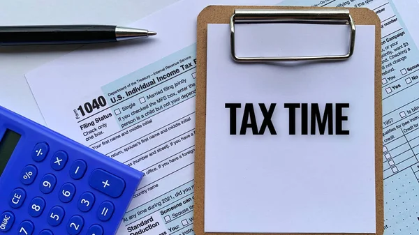 Horní pohled na text notepadu - Daňový čas. S daňovým formulářem, kalkulačkou a perem na pozadí. — Stock fotografie