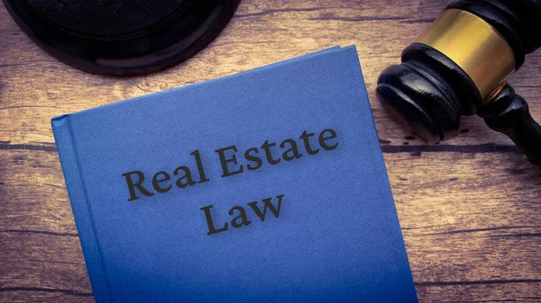 Real estate Law book και σφυρί σε ξύλινο τραπέζι. — Φωτογραφία Αρχείου