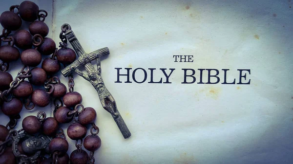 Draufsicht auf den Bibeltext mit Rosenkranz auf der alten Bibel. — Stockfoto
