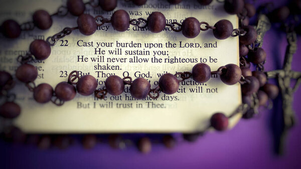 Top view of Bible verses with blurred Holy Rosary Background.