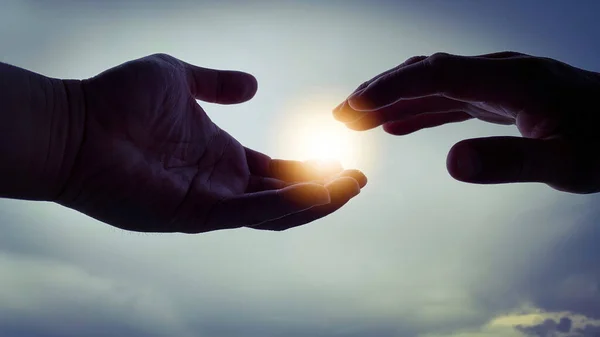 Due mani cercano di raggiungere la luce splendente. — Foto Stock