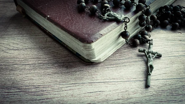 나무 책상 위에 놓인 성경 과 거룩 한 묵주. — 스톡 사진