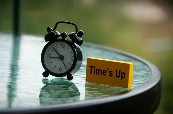 Tiden går upp text på gult träblock med väckarklocka bakgrund. Tidsbegrepp — Stockfoto