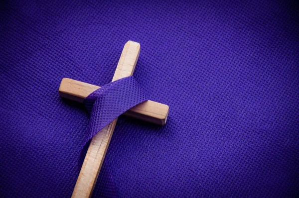 Religiöses Kreuz auf violettem Hintergrund. Karfreitagskonzept — Stockfoto