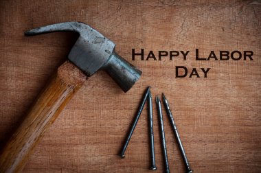 Tahta masadaki metin manzarası - Çekiç ve çivi arkaplanlı İşçi Bayramı 'nız kutlu olsun. İşçi Bayramı konsepti