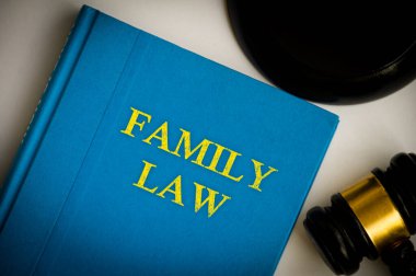 Beyaz arka planda tokmağı olan aile hukuku kitabının en üst görüntüsü. Hukuk kavramı.