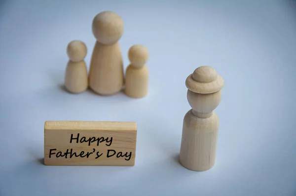 Happy father\'s day wishes text on wooden block with wooden doll model of a father and family. Happy Father\'s Day concept