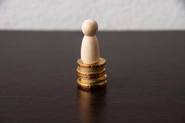 Tahta bebek model geçmişi olan bozuk para yığını - Başarı ve iş konsepti