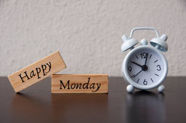 Beyaz alarmlı tahta bloklarda mutlu Pazartesi metinleri. Selamlama konsepti