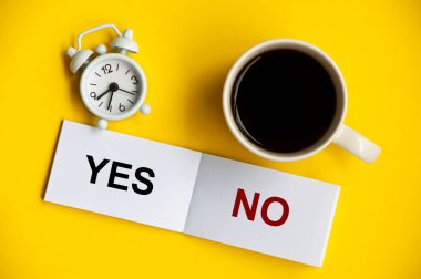 Evet, not defterinde alarm saati ve sarı arka planda kahve fincanı yok. Karar ve iş konsepti.