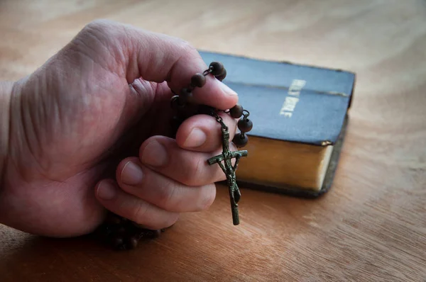 Dorosły Człowiek Ręka Trzymając Różaniec Święty Podczas Modlitwy Tła Biblii — Zdjęcie stockowe