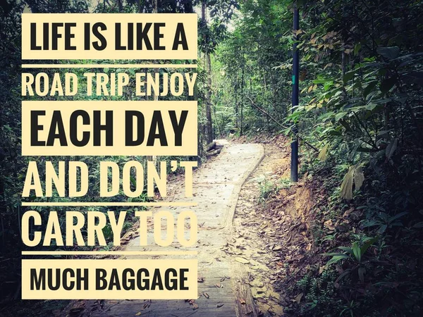Motivational and Inspiration quote text - Life is like a road trip enjoy each day and don\'t carry too much baggage. With hiking Trail pathway background.