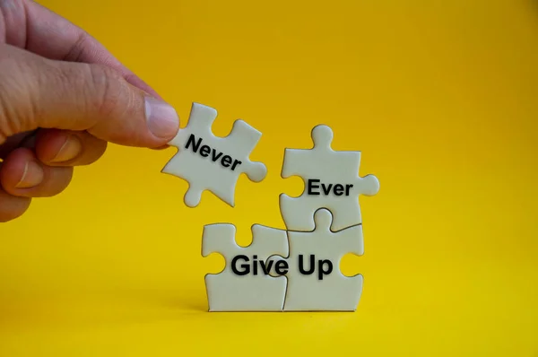Motivational Text Jigsaw Puzzle Hand Holding Missing Jigsaw Never Ever — Stock Photo, Image