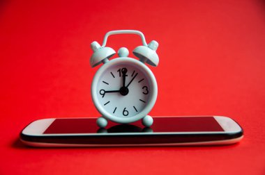 Akıllı bir telefonda çalar saat 9 'u işaret ediyor. Kırmızı kapaklı arka plan. Boşluğu kopyala