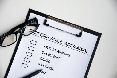 Performans Değerlendirme listesinin en üst görünümü klip tahtasında kalem ve gözlüklerle.