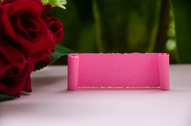 Gülleri ve bitki arkaplanı olan boş pembe bir kağıt. Boşluğu kopyala