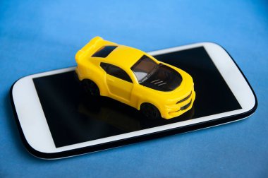 Araba akıllı telefonun üstünde. İş ve yaşam tarzı kavramı 