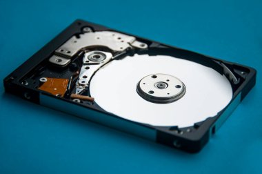 Sabit disk sürücüsünün mavi kapaklı arka plandaki soyut görüntüsü. Veri, donanım ve bilgi teknolojisi kavramı.