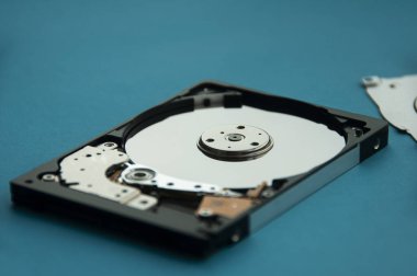 Sabit disk sürücüsünün mavi kapaklı arka planındaki soyut görüntüsünü kapat. Veri, donanım ve bilgi teknolojisi kavramı.