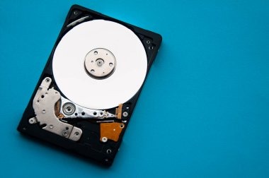 Sabit disk sürücüsünün mavi kapaklı arka plandaki soyut görüntüsü. Veri, donanım ve bilgi teknolojisi kavramı.