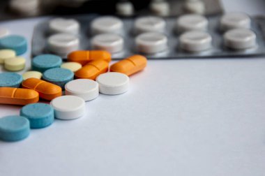 Çeşitli ilaç hapları, haplar ve beyaz arka planı bulanık olan kapsüller. Sağlık ve ilaç kavramı. Boşluğu kopyala.