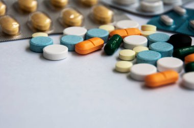 Çeşitli ilaç hapları, haplar ve beyaz arka planı bulanık olan kapsüller. Sağlık ve ilaç kavramı. Boşluğu kopyala.