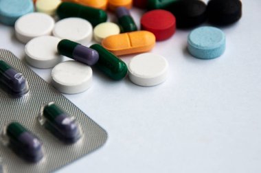 Çeşitli ilaç hapları, haplar ve beyaz arka planı bulanık olan kapsüller. Sağlık ve ilaç kavramı. Boşluğu kopyala.