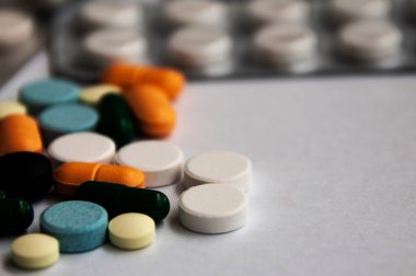 Çeşitli ilaç hapları, haplar ve beyaz arka planı bulanık olan kapsüller. Sağlık ve İlaç kavramı.