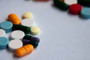 Çeşitli ilaç hapları, haplar ve beyaz arka planı bulanık olan kapsüller. Sağlık ve ilaç kavramı. Boşluğu kopyala.