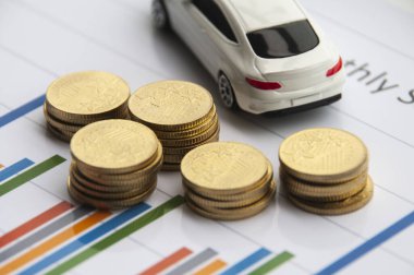 İş konsepti. Altın sikkeler ve oyuncak araba arka planıyla veri analizi.