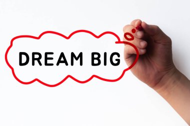Hand writing Dream Big in cloud bubble on transparent wipe board.