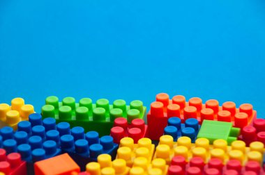 Mavi arka planda plastik yapı taşları. Boşluğu kopyala.