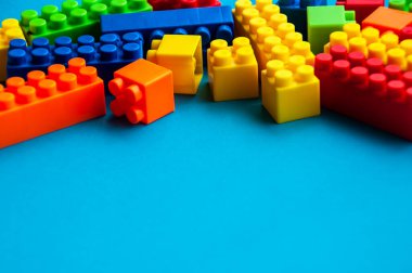 Mavi arka planda plastik yapı taşları. Boşluğu kopyala.