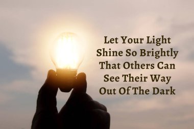Motivational and Inspirational quote about inspire others. With hand holding light bulb in vintage color background. Motivational concept