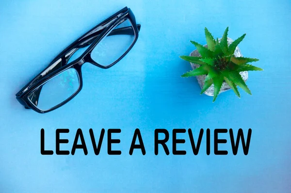 Leave Review Text Light Blue Cover Potted Plant Glasses Background — Stock Photo, Image