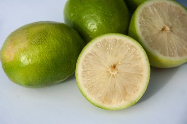 Beyaz arka planda yeşil çekirdeksiz limonlar. Tam alan derinliği.