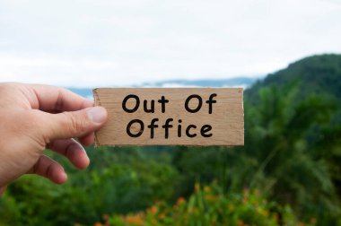 El ele tutuşan ahşap afiş - ofis dışında.