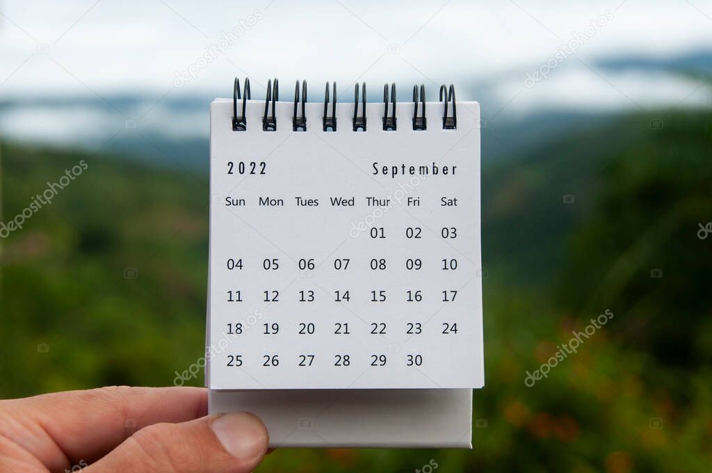 Hand holding September 2022 calendar with copy space.