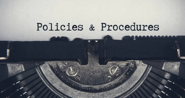 Policies and procedures text typed on an old vintage typewriter.