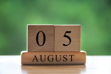 August 5 calendar date text on wooden blocks with blurred background park. Calendar concept