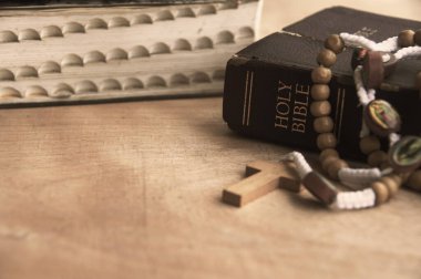 Holy Bible and Rosary on a wooden table with customizable space to add ideas or text. Copy space and Christianity concept.