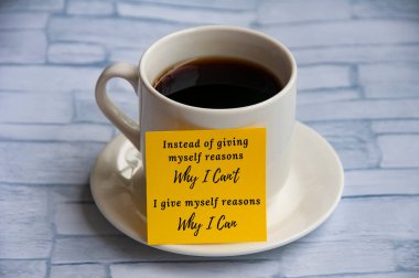 Motivational quote on yellow notepad with coffee cup background - Instead of giving myself reasons why I can't, I give myself reasons why i can. Motivational concept