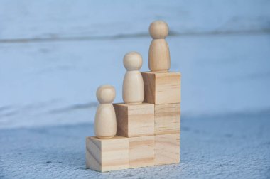Tahta blokların tepesindeki tahta figürler. Kariyer gelişimi ve liderlik kavramı.